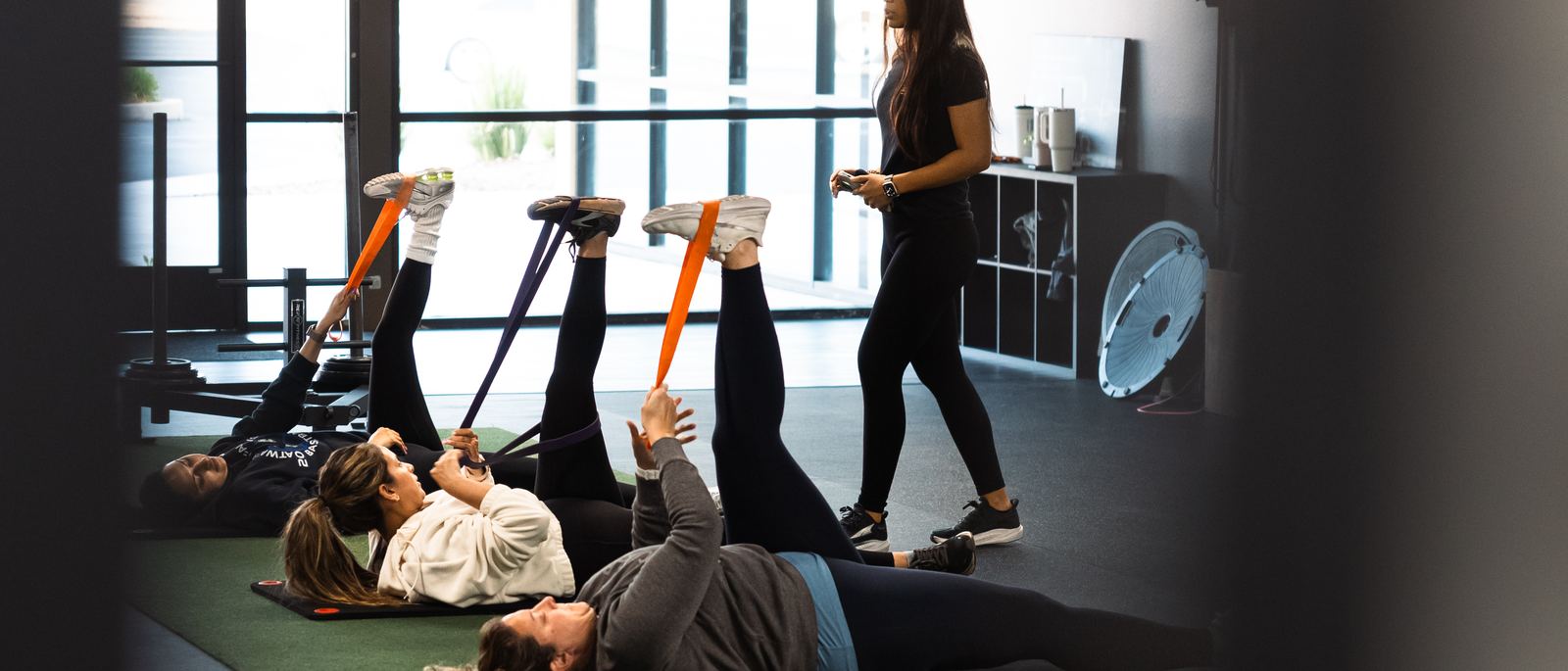 Women strength training together in a semi-private session at Merced Elite Gym, a women's-only private studio in Merced, California, with a coach supervising the floor
